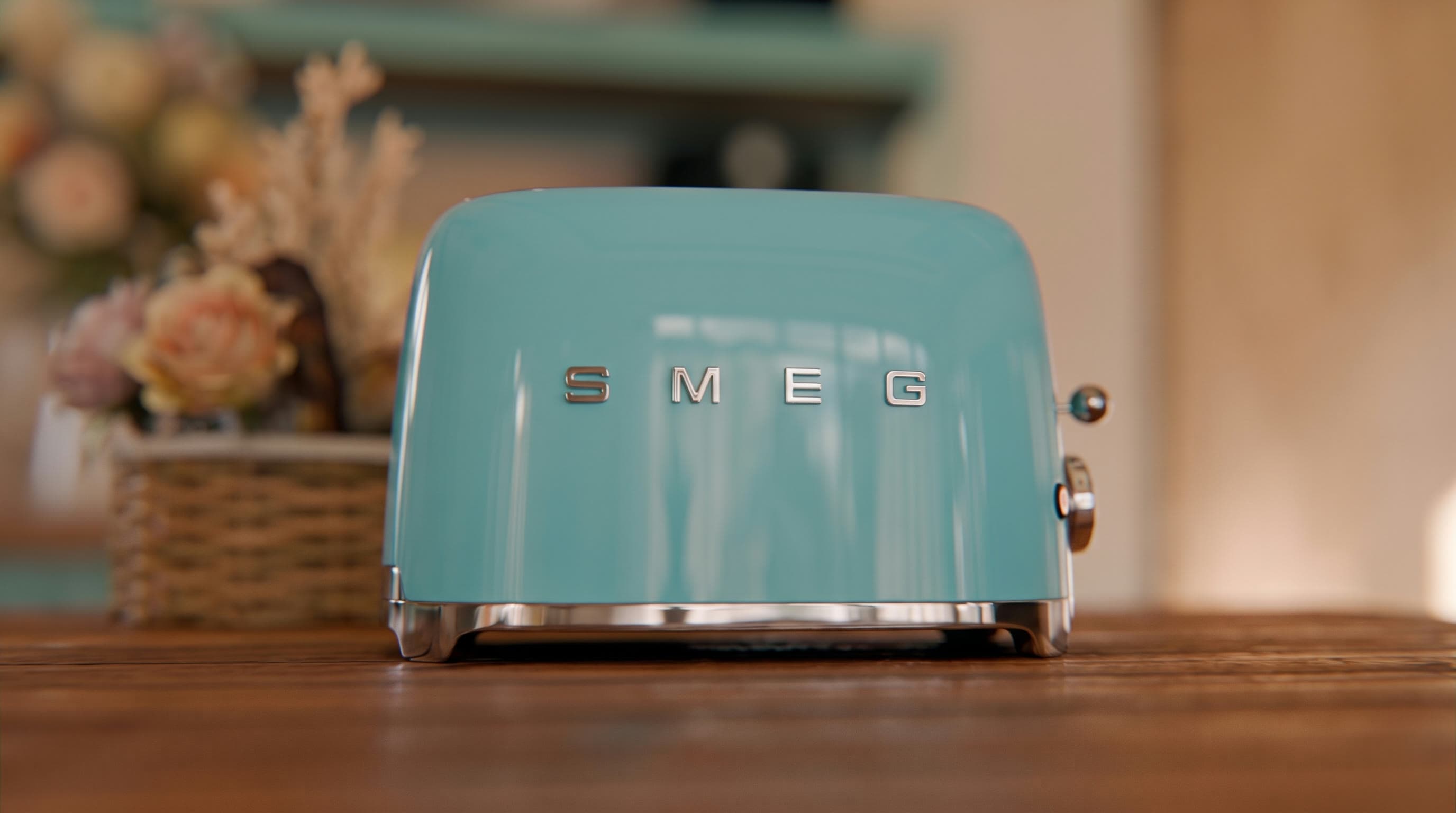 A teal SMEG toaster seen front on, rendered for All About Home